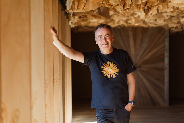 Na fotografii je ředitel a spolumajitel českého SONNENTORU, Josef Dvořáček. Opírá se o dřevěnou lamelu na okně exkurzní trasy v Bylinkovém ráji SONNENTOR. | © SONNENTOR